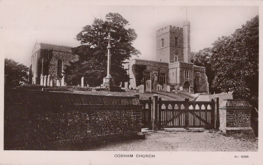 Gothic-style church with stone walls and a tall tower, surrounded by trees and a wooden gate.