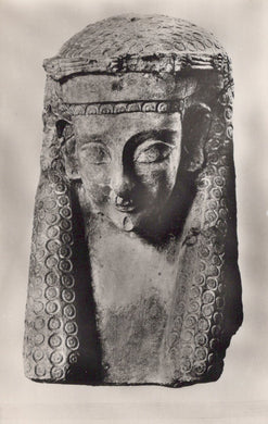 Statue head with intricate detailing on a plain background