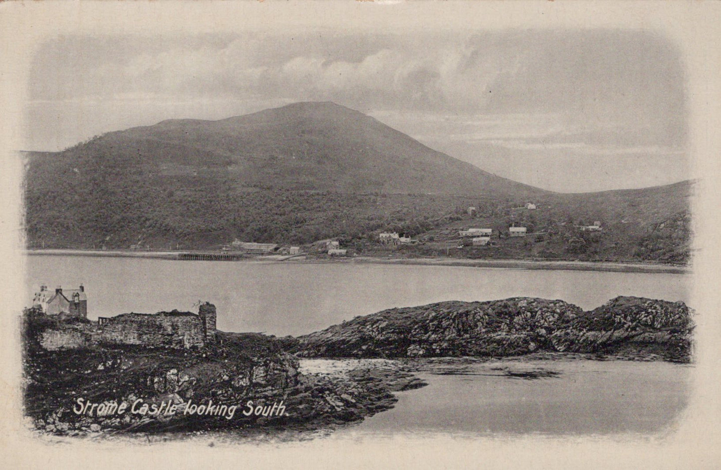 Vintage black and white postcard of a coastal scene with a castle and mountains.