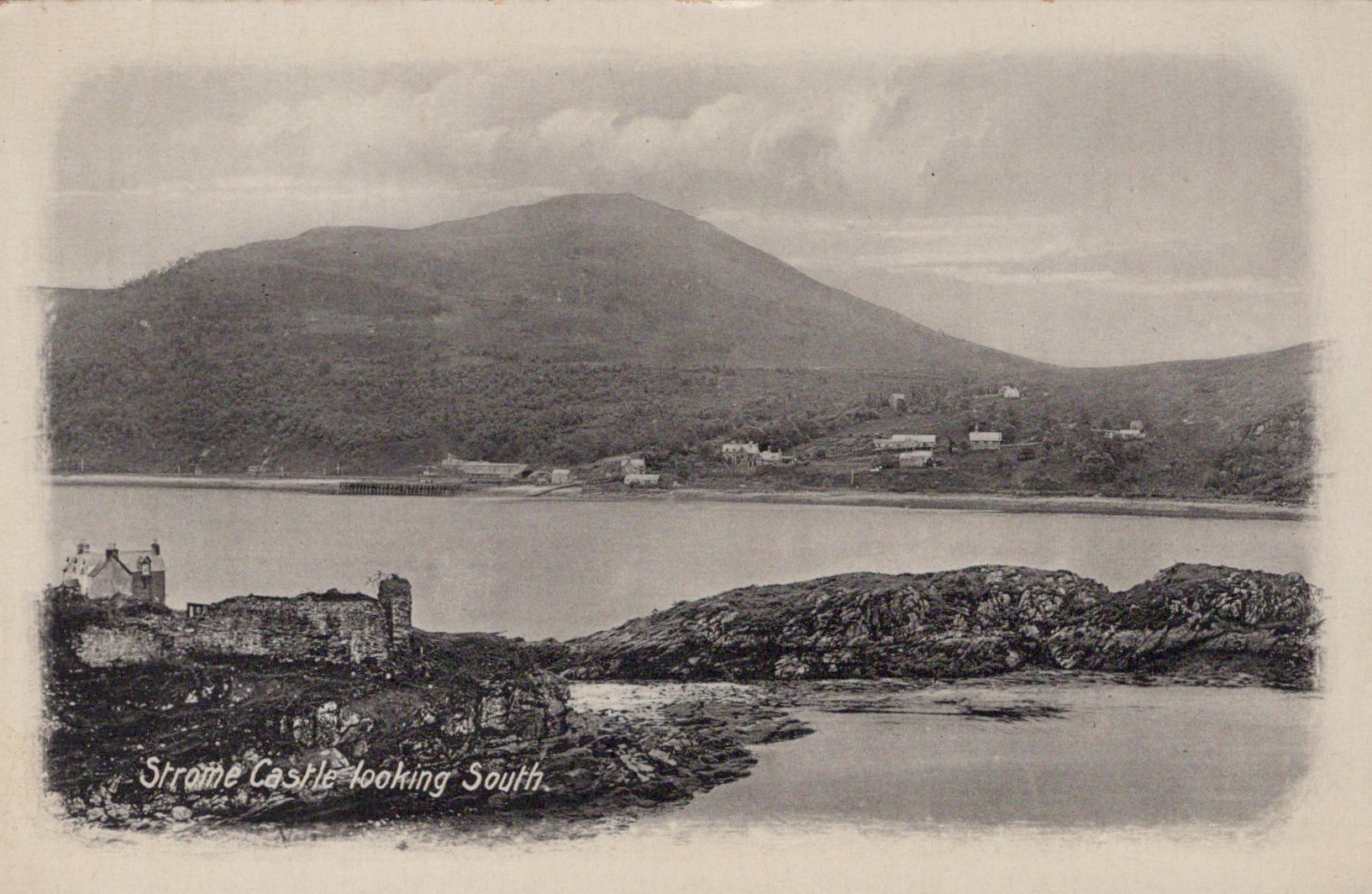 Vintage black and white postcard of a coastal scene with a castle and mountains.