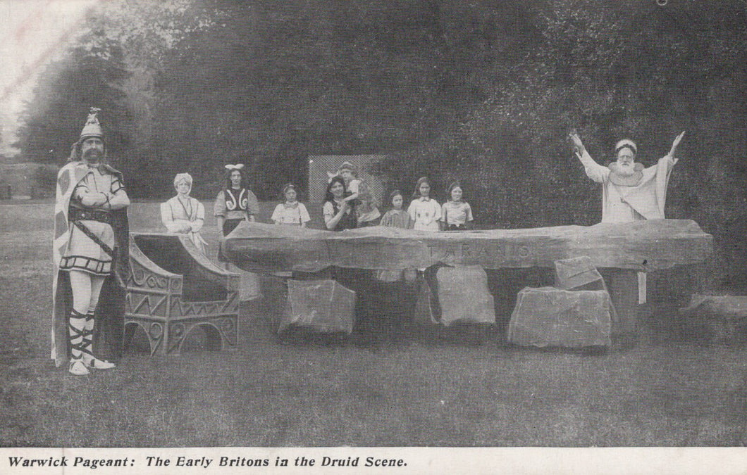 Historical performance scene with people in costumes around a stone circle.
