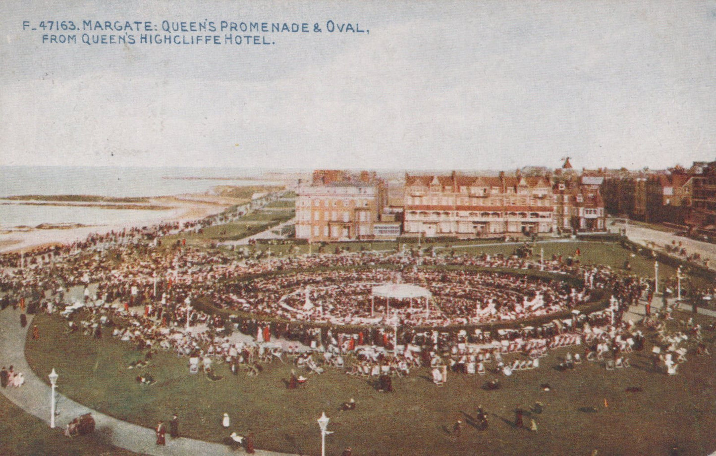Vintage postcard of Queens Promenade and Oval in Margate, featuring a large crowd gathered around a bandstand.