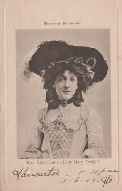 Vintage photograph of a woman wearing a large hat with decorative elements, dressed in an elegant outfit.