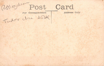 Vintage postcard with text and signature on a textured beige background