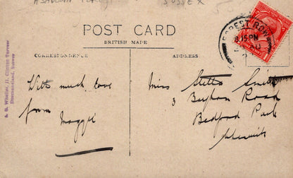 Vintage postcard with handwritten text and a red stamp on a brown background