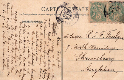 Vintage postcard with stamps and cursive writing on a brown background