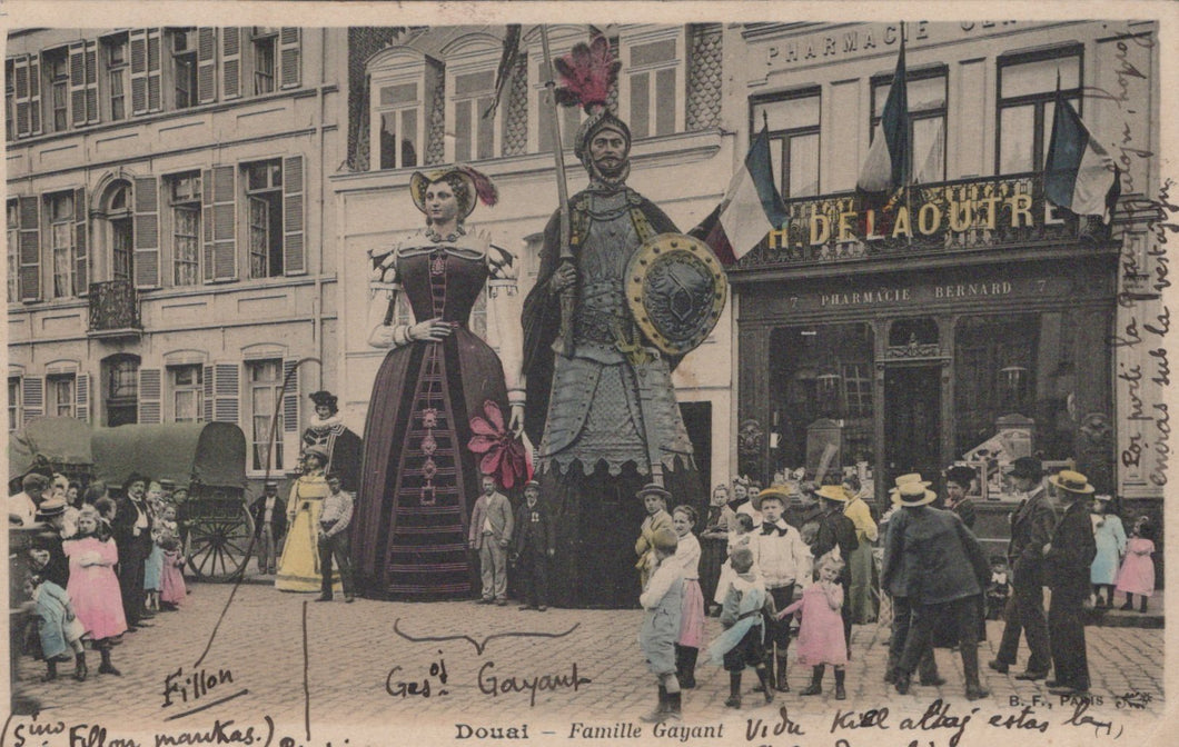 Vintage postcard of giant figures in a street scene with people and buildings.