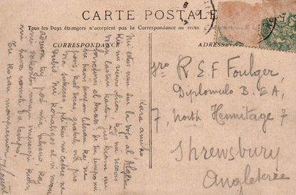 Vintage postcard with text and stamps, featuring a handwritten address.