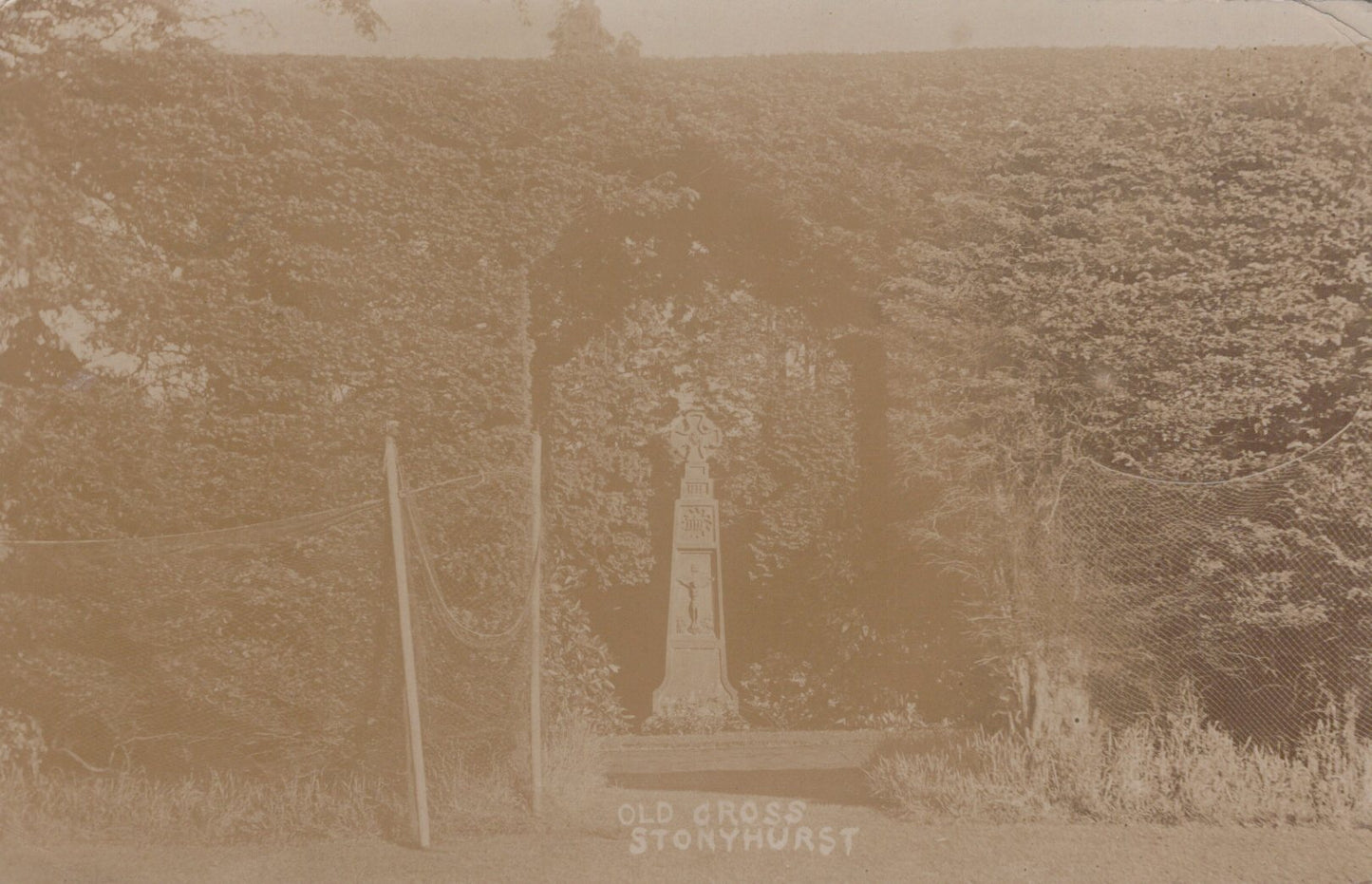 Monument in a field with 'Old Cross Stonehurst' text, sepia tone
