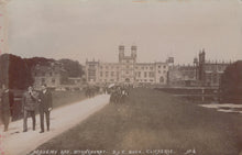 Load image into Gallery viewer, Vintage photograph of a large building with two men walking on a path in front.
