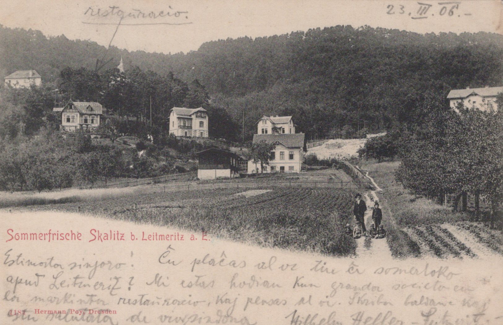 Vintage black and white photo of a village with houses and people on a path, dated 23. V. 06.