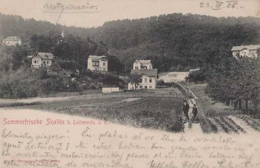 Vintage black and white photo of a village with houses and people on a path, dated 23. V. 06.