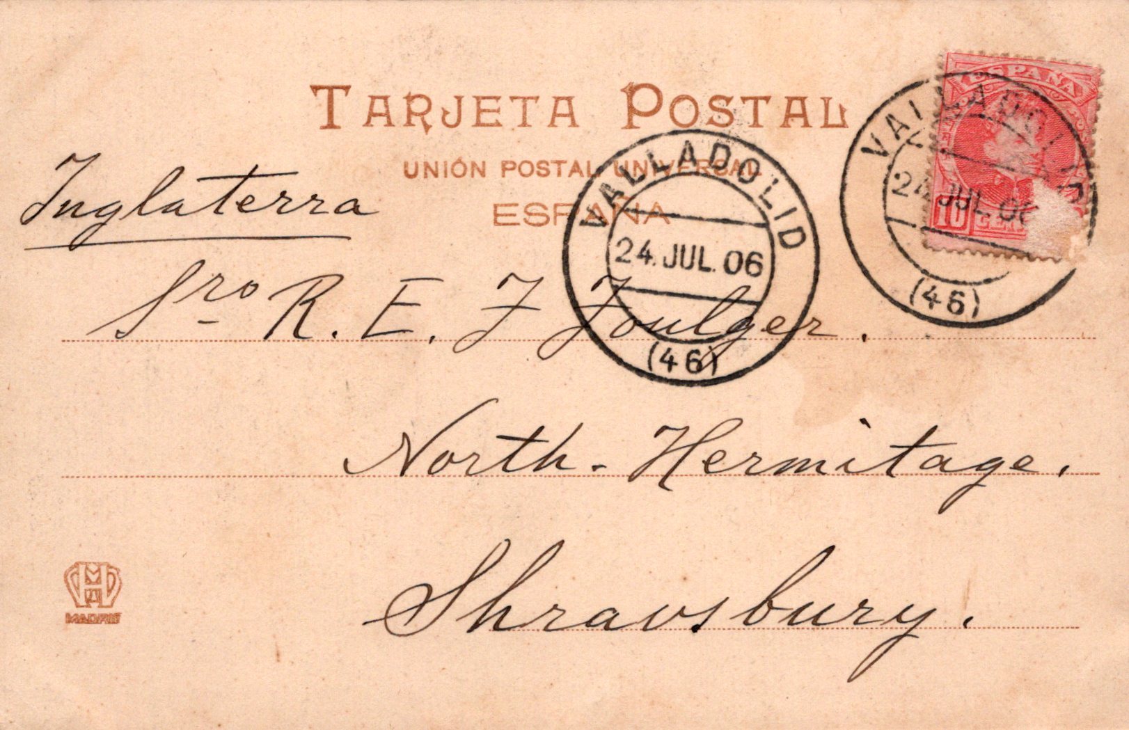 Vintage postcard with stamps and text, featuring a red stamp and black text on a brown background.
