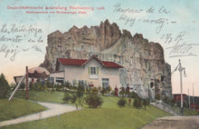 Load image into Gallery viewer, Vintage postcard of a building embedded in a rocky cliff with people around, labeled &#39;Deutschbähmische Ausstellung Reichenberg 1908&#39;.
