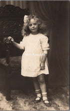 Load image into Gallery viewer, Ancestors Postcard - Young Girl Stood Next to an Ornate Wooden Chair  SW16846
