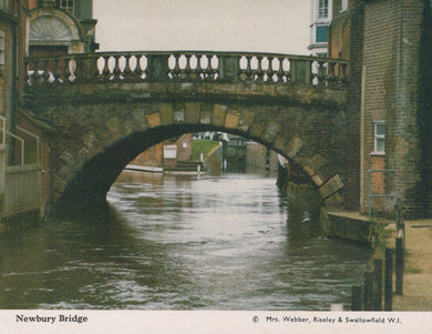 Bridge over a canal with buildings on either side, featuring a watermill.