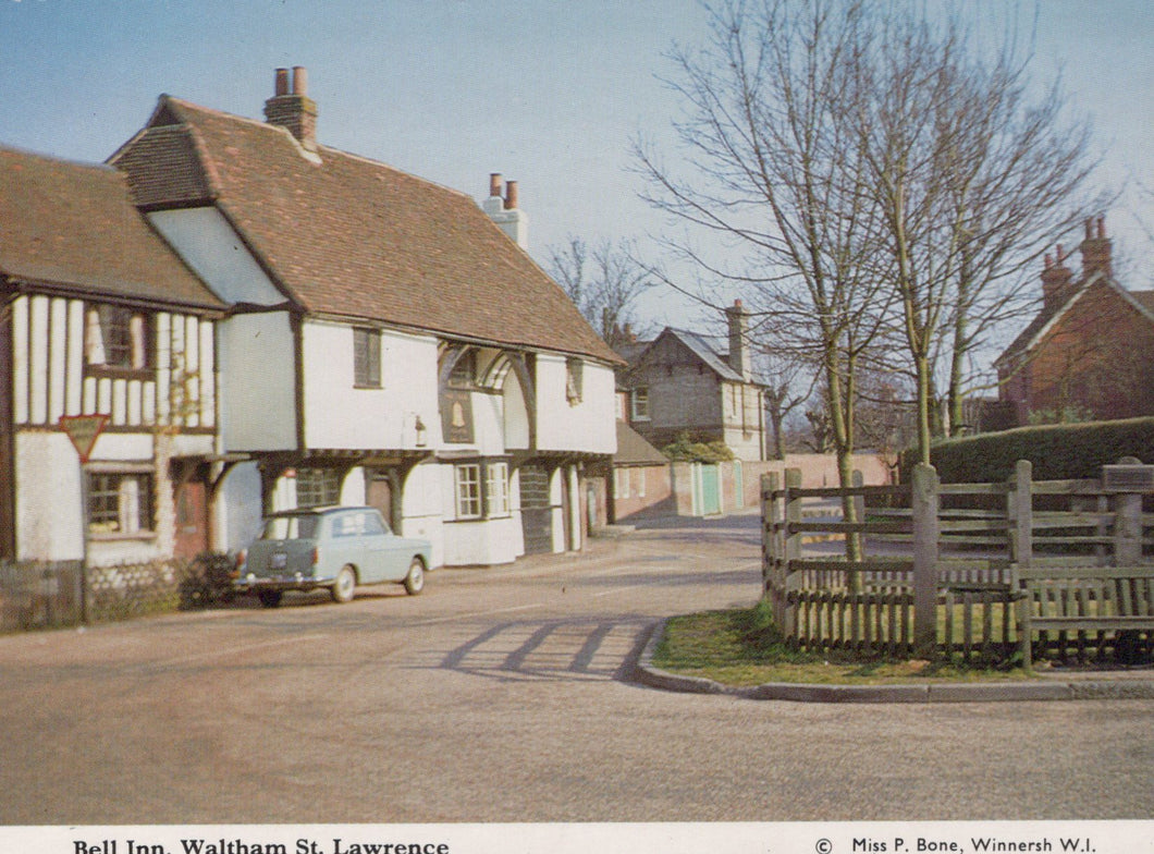 Vintage photograph of a street scene with a half-timbered building and a car parked on the side.