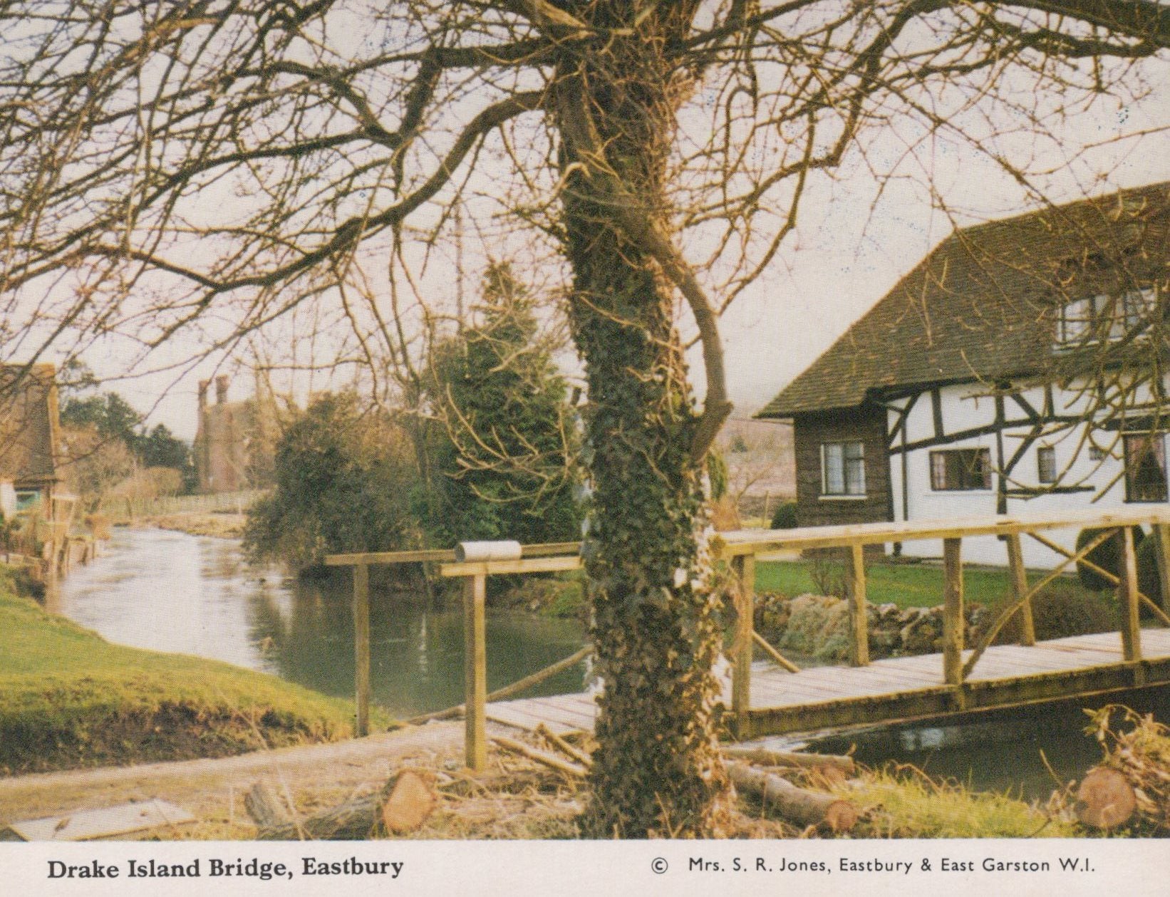 Bridge over a river with a house and trees in the background at Drake Island Bridge, Eastbury.
