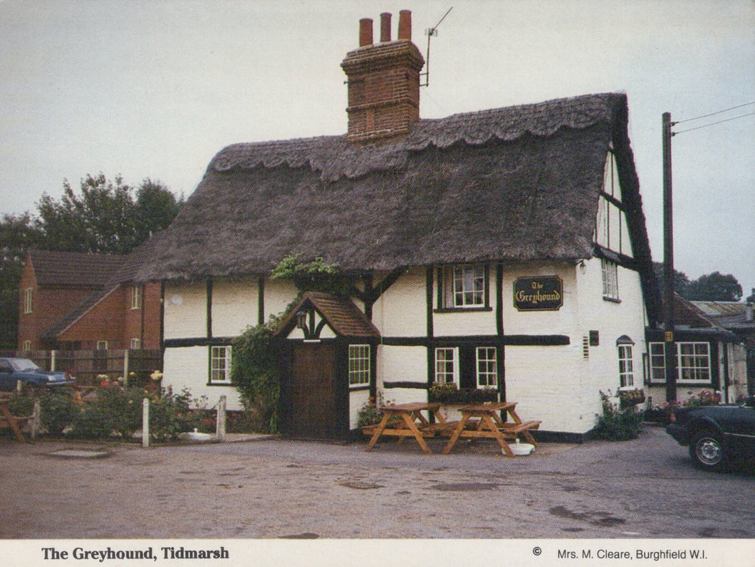 Traditional English pub with thatched roof in Tidmarsh, featuring a sign for 'The Greyhound'.