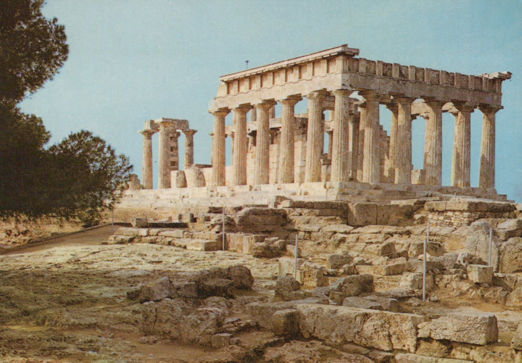 Ancient temple ruins with columns and stone foundations against a clear sky.