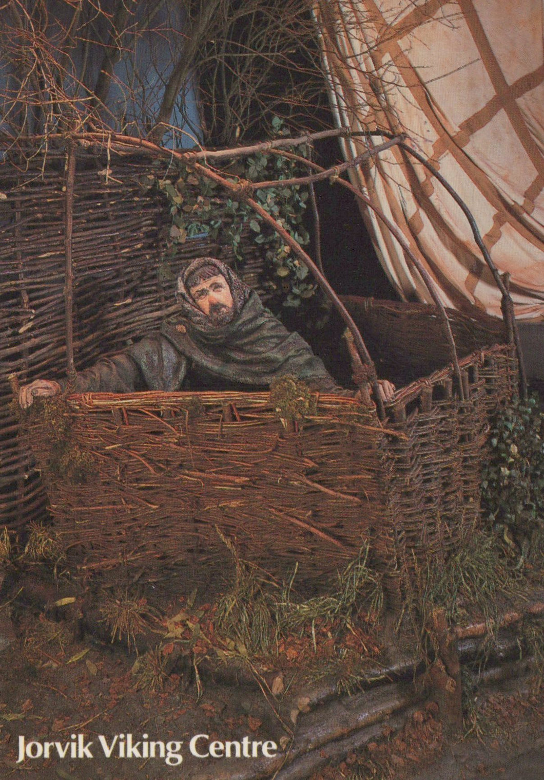 Man in a wicker boat with a Viking ship in the background, Jorvik Viking Centre branding.