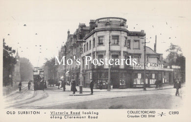 Vintage black and white postcard of a street scene with buildings and people on a street corner.