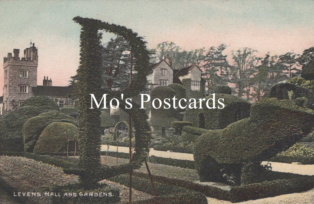 Topiary garden with shaped bushes in the shape of a chair and table, with 'Mo's Postcards' text overlay.