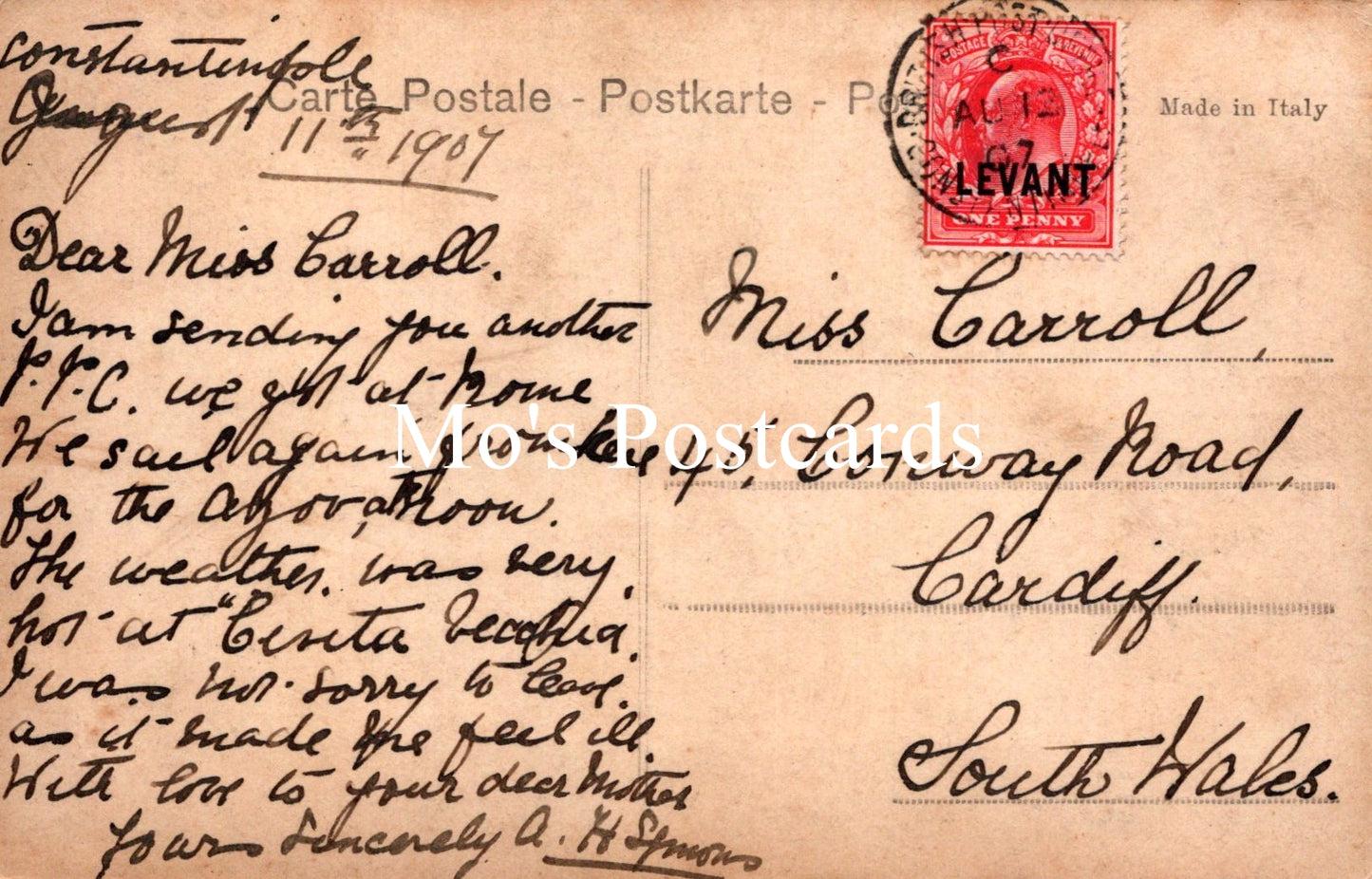 Vintage postcard with text and a red stamp, addressed to Miss Carroll in Cardiff, South Wales.