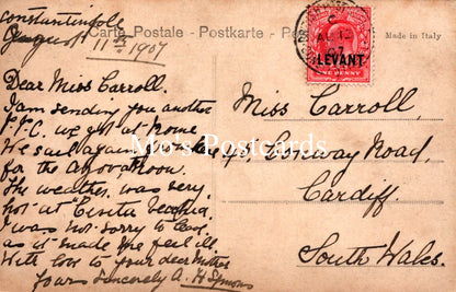 Vintage postcard with text and a red stamp, addressed to Miss Carroll in Cardiff, South Wales.