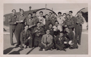 Group of men in military uniforms posing in front of an airplane