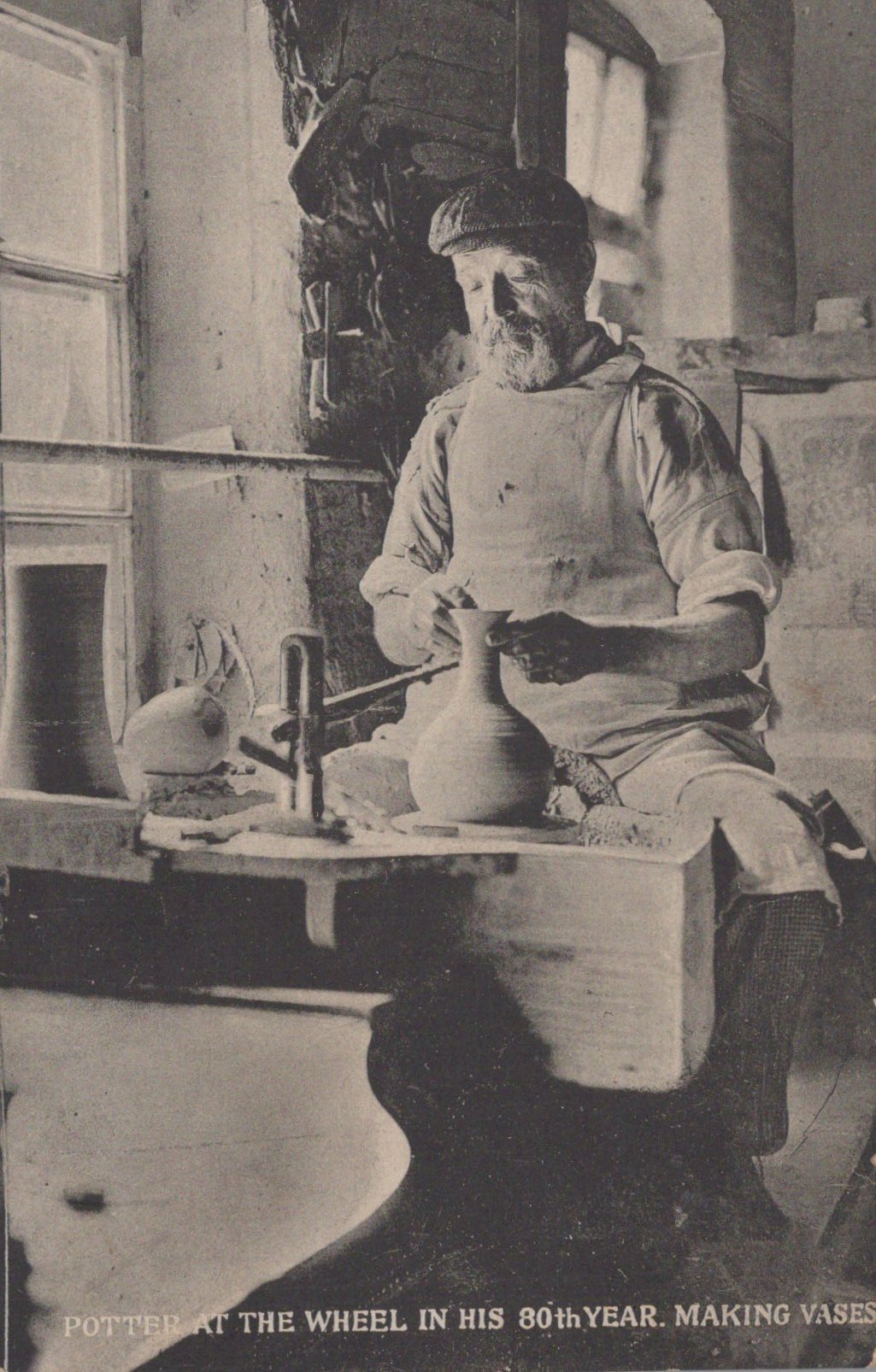 Black and white photograph of a potter at work in his studio, with text indicating he is making vases.
