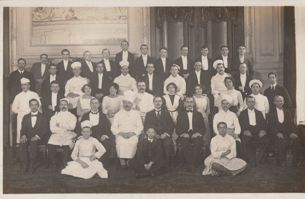 Vintage black and white photograph of a formal group of people in formal wear, likely from an earlier century.