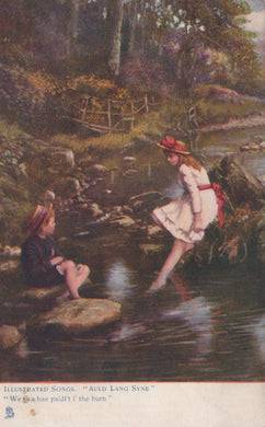 Two children by a stream in a natural setting with a bridge in the background.