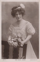 Load image into Gallery viewer, Vintage black and white portrait of a woman holding flowers, wearing an ornate dress and hat.
