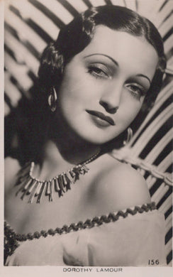 Vintage black and white portrait of a woman with decorative jewelry against a patterned background