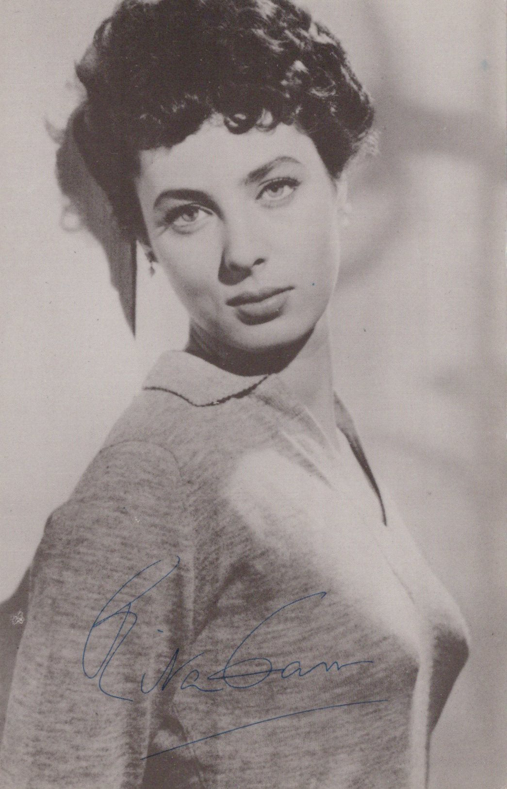 Black and white portrait of a woman wearing a sweater with a signature at the bottom.