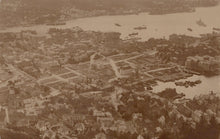 Load image into Gallery viewer, Aerial view of a city with a river and boats, vintage black and white photo
