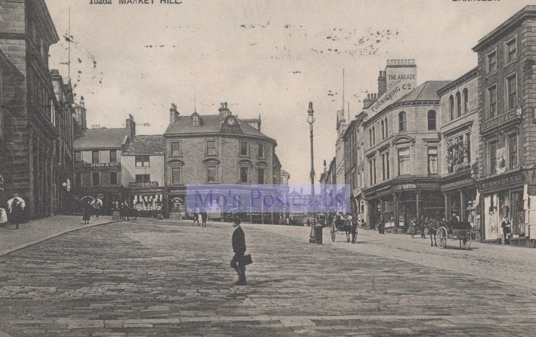 Vintage black and white photograph of a town square with people and buildings.