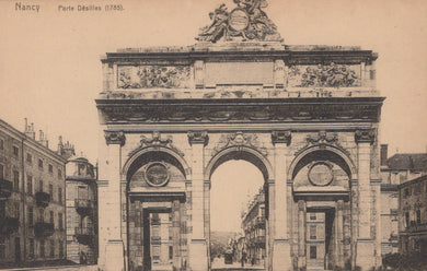 Vintage photograph of a stone archway with decorative elements, likely a historical monument, in a city setting.