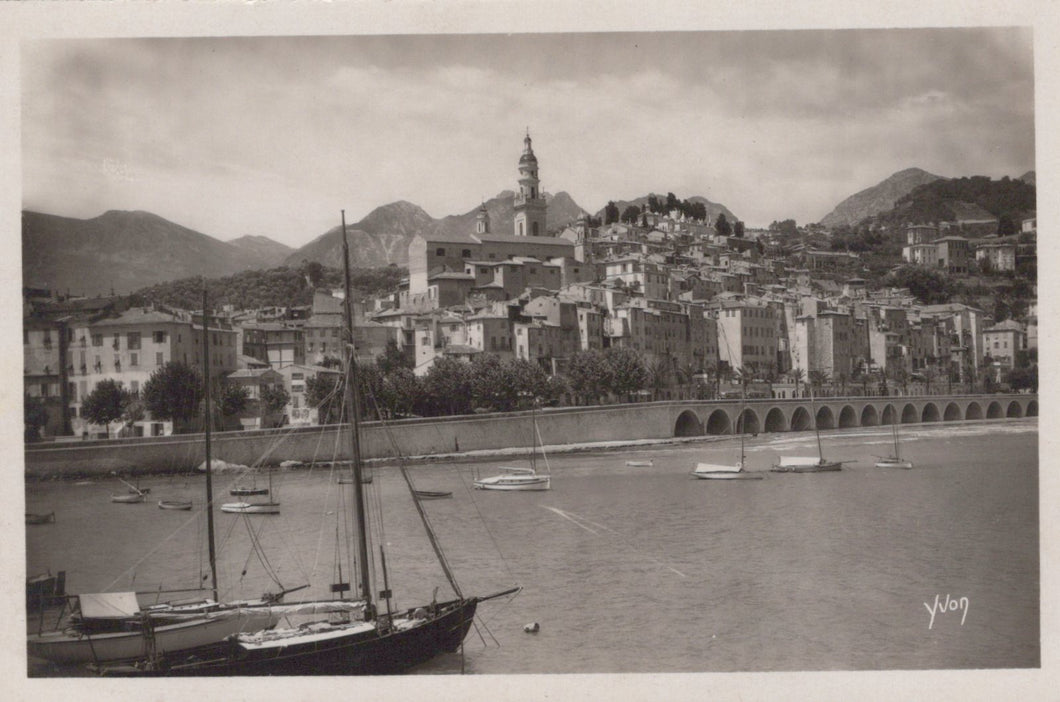 Vintage black and white photo of a coastal town with boats on the water
