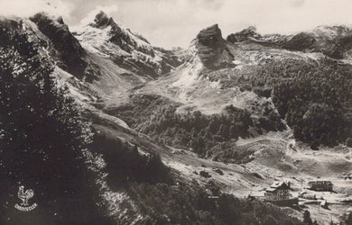 Vintage black and white photograph of a mountainous landscape with a small settlement.