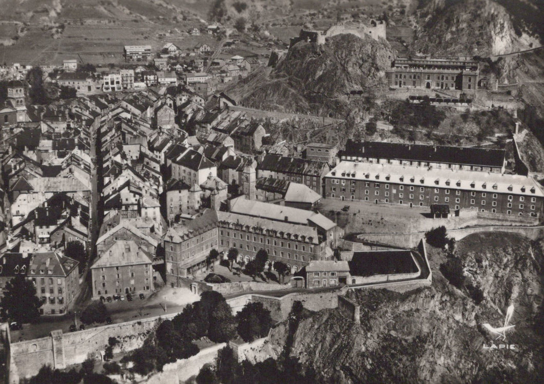 Vintage black and white aerial view of a city with historical buildings and a castle.