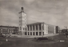 Load image into Gallery viewer, Vintage black and white photo of a large building with a clock tower and surrounding street scene.
