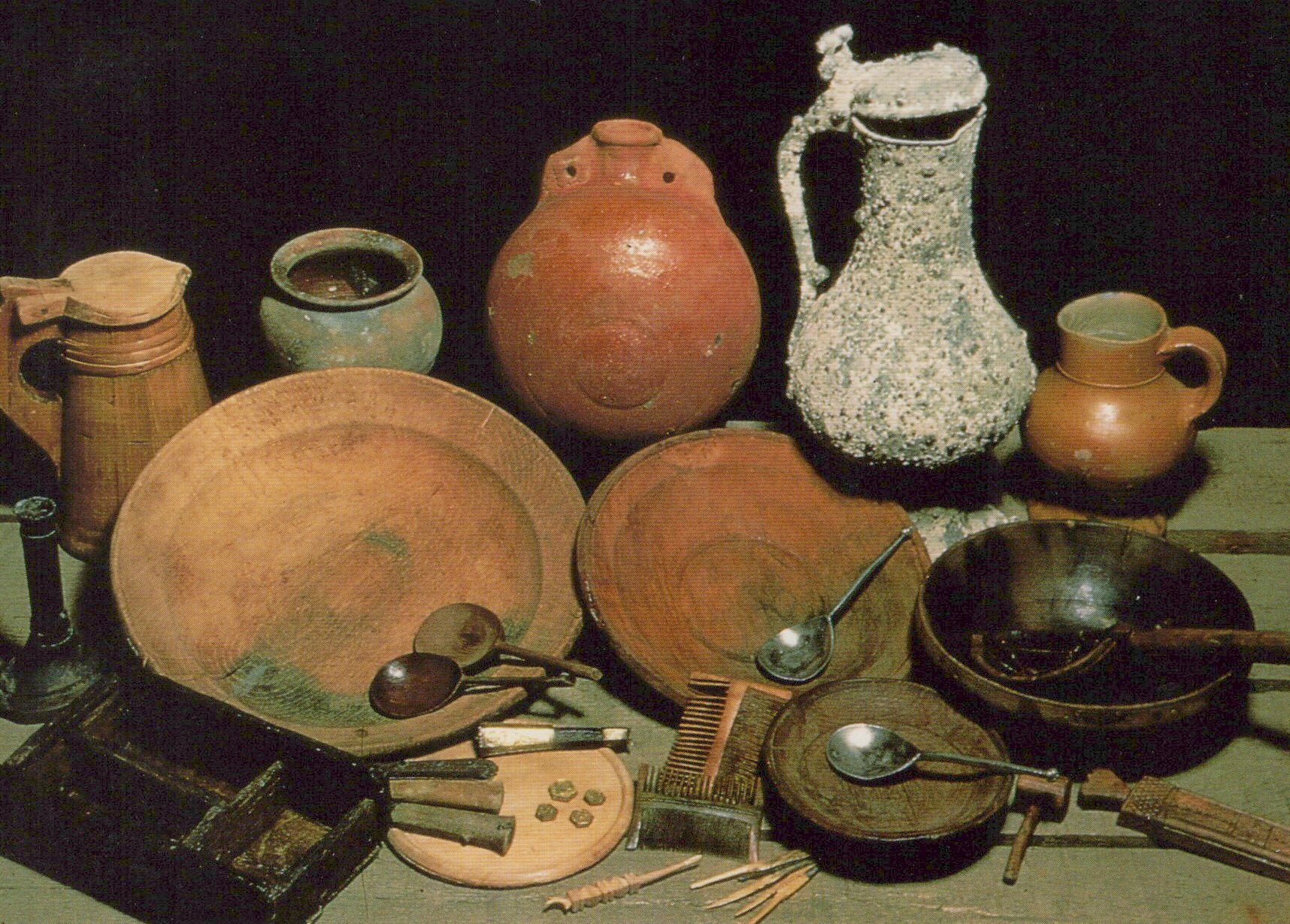 Collection of ancient pottery and utensils on a dark background
