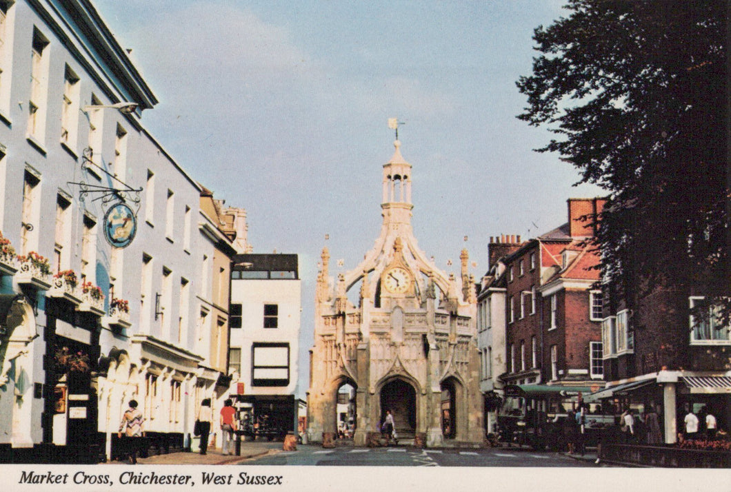 Market Cross in Chichester, West Sussex with buildings and people around.
