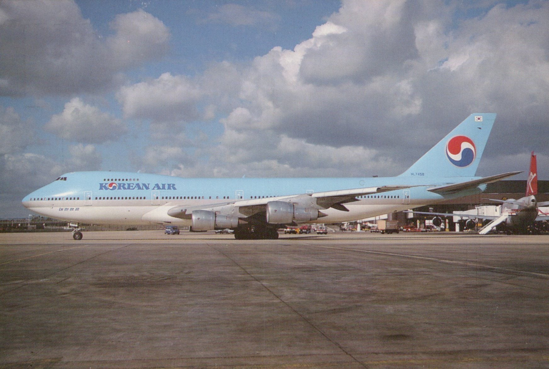 Korean Air airplane on a runway with a cloudy sky