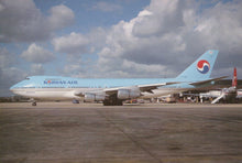 Load image into Gallery viewer, Korean Air airplane on a runway with a cloudy sky
