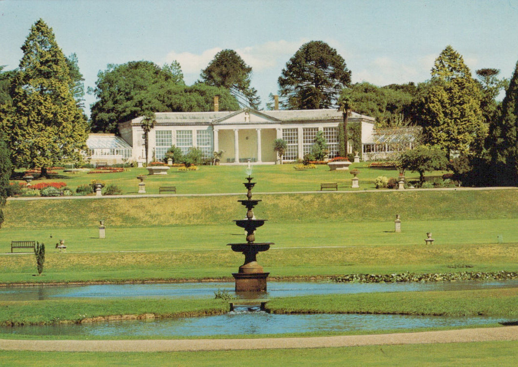 Orangery building with a fountain and garden in the foreground