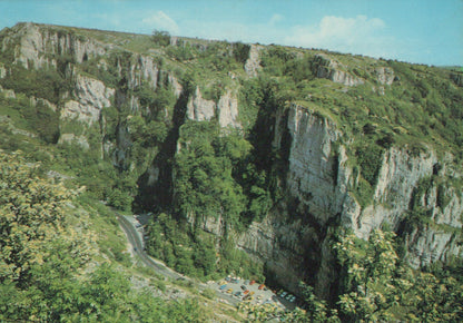 Scenic view of a deep canyon with steep cliffs and a winding road.