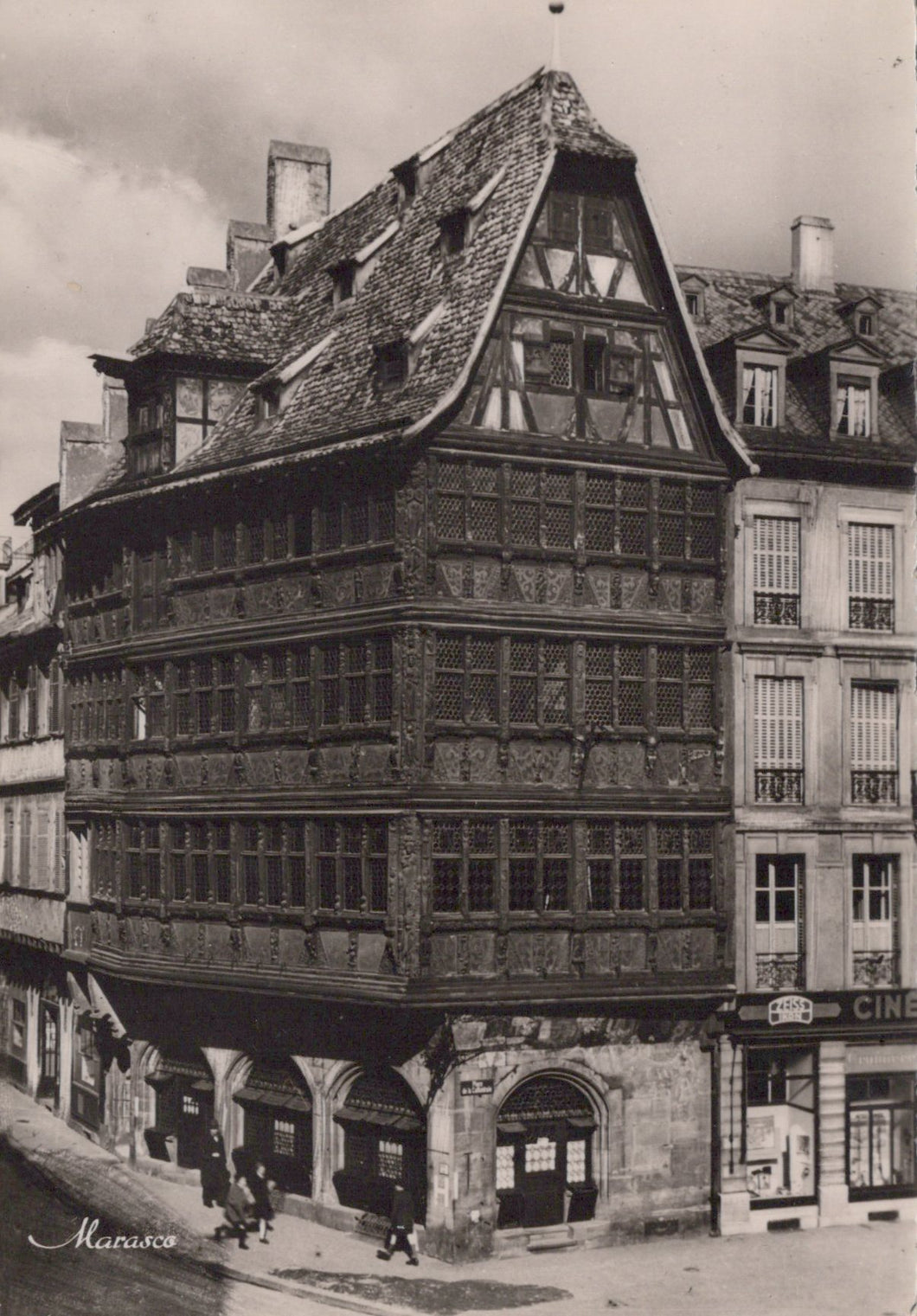 Historical black-and-white photograph of a corner building with wooden facade on a street.